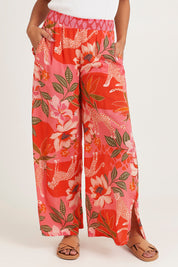 Model Ziara wearing size 10 of the Aria Pant in colour Print (Pink), from the front, cropped image