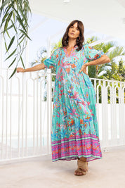 A model wearing the Marina Maxi Dress in colour Print (Blue), from the front, showing the whole outfit