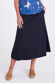 Model Emma wearing size S of the Amy Skirt in colour Navy (Blue), from the front, cropped image