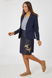 Model Cara wearing size S of the 2 Birds Denim Skirt in colour PuttyDenim (Blue), from the front, showing the whole outfit