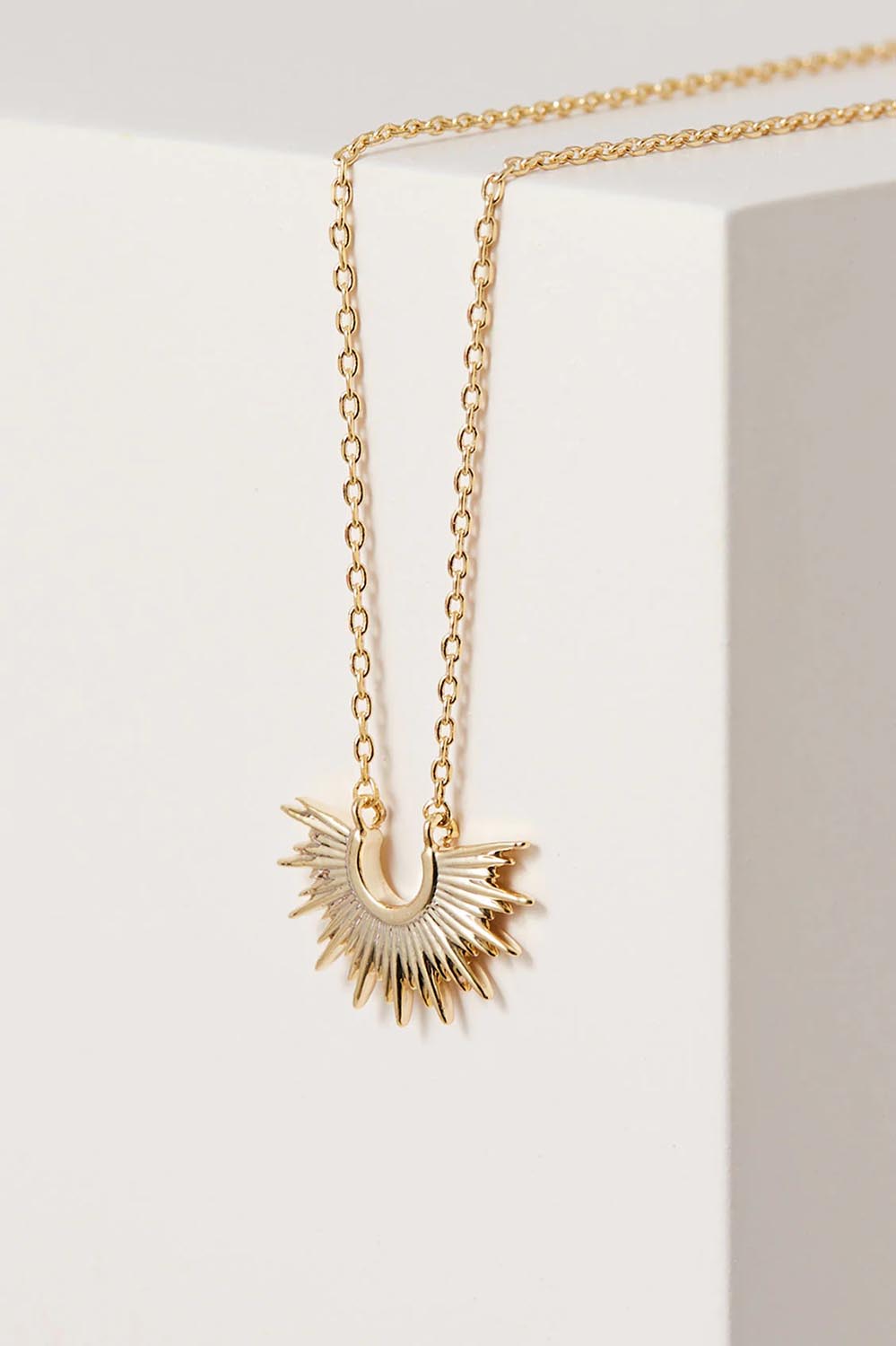 A model wearing the Half Sunburst Necklace in colour Gold (Metallics), from the front, showing the whole outfit