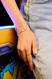 A model wearing the Pearl Station Gold Amelia Bracelet in colour Goldpearl (Metallics), from the front, cropped image