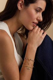 Model Genericm wearing size sample of the Moon & Stars Charm Bracelet – Gold in colour Gold, from an angle