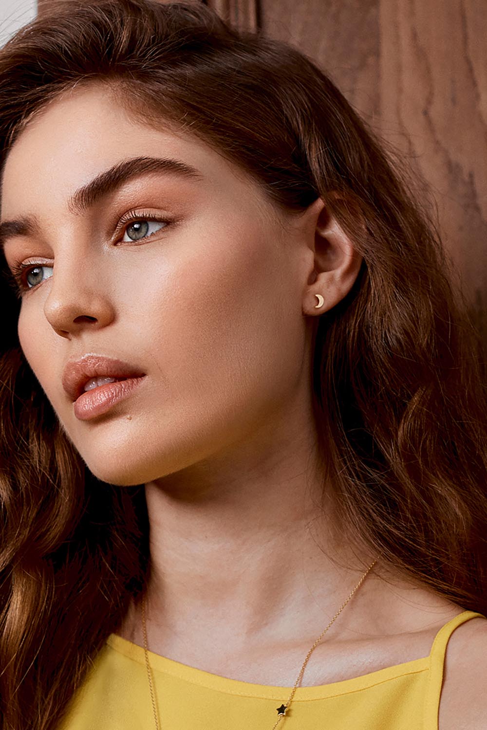 A model wearing the Mixed Moon & Star Stud Earring in colour Gold (Metallics), from the front, cropped image