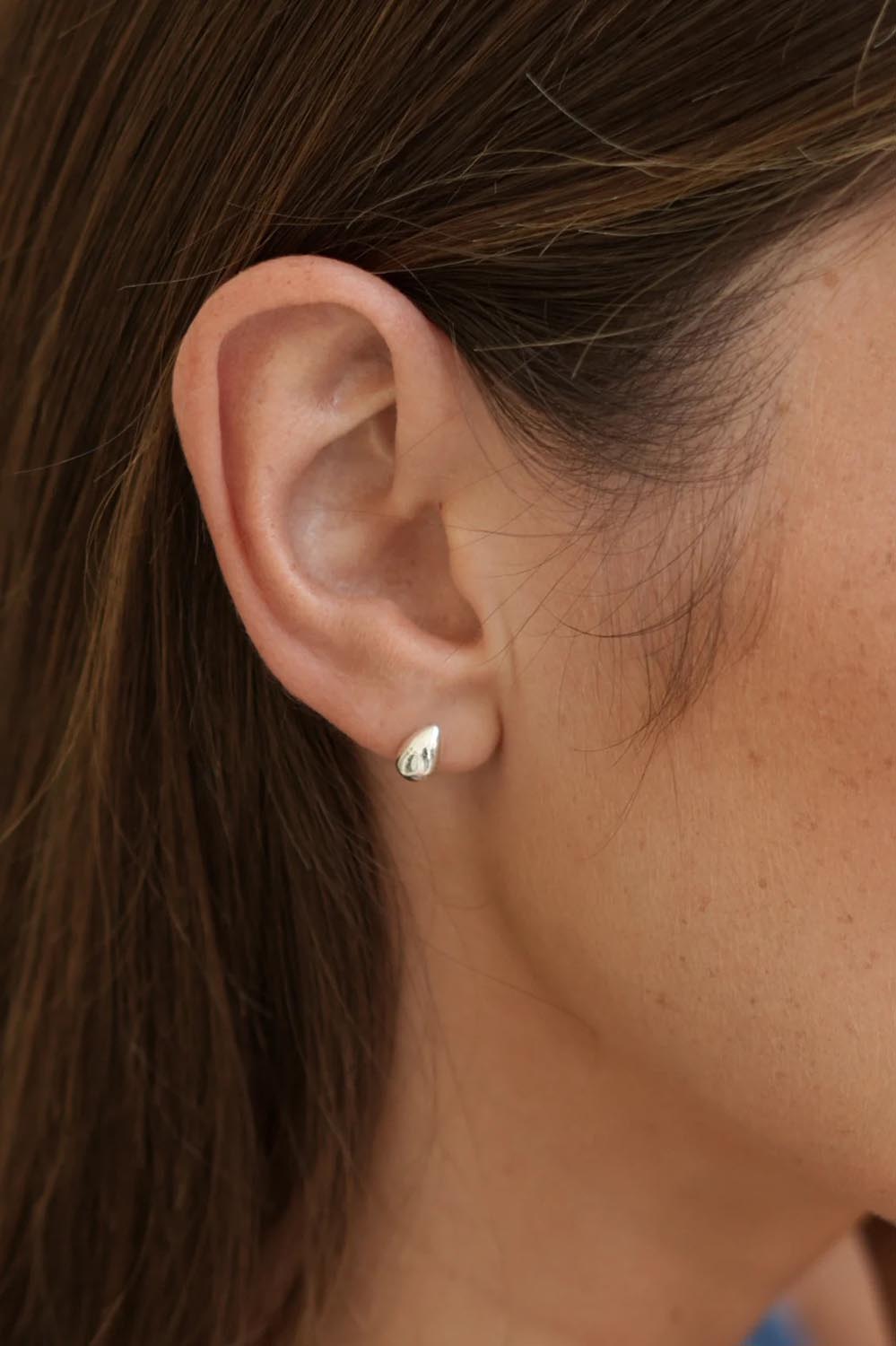 Model Genericm wearing size sample of the Mini Teardrop Earrings – Silver in colour Silver, from an angle