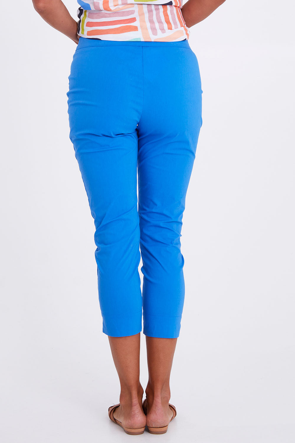 Model Alex wearing size 10 of the Fuss Free Cotton Blend 7/8 Taper Capri in colour Azure (Blue), from the back