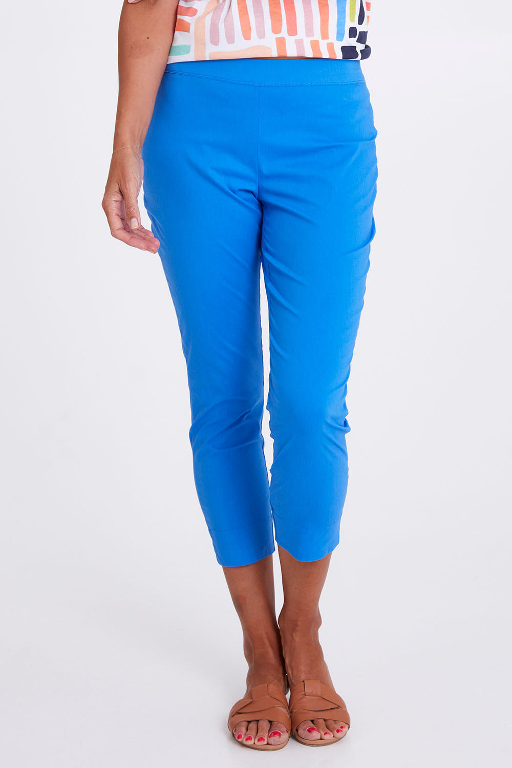 Model Alex wearing size 10 of the Fuss Free Cotton Blend 7/8 Taper Capri in colour Azure (Blue), from the front, cropped image