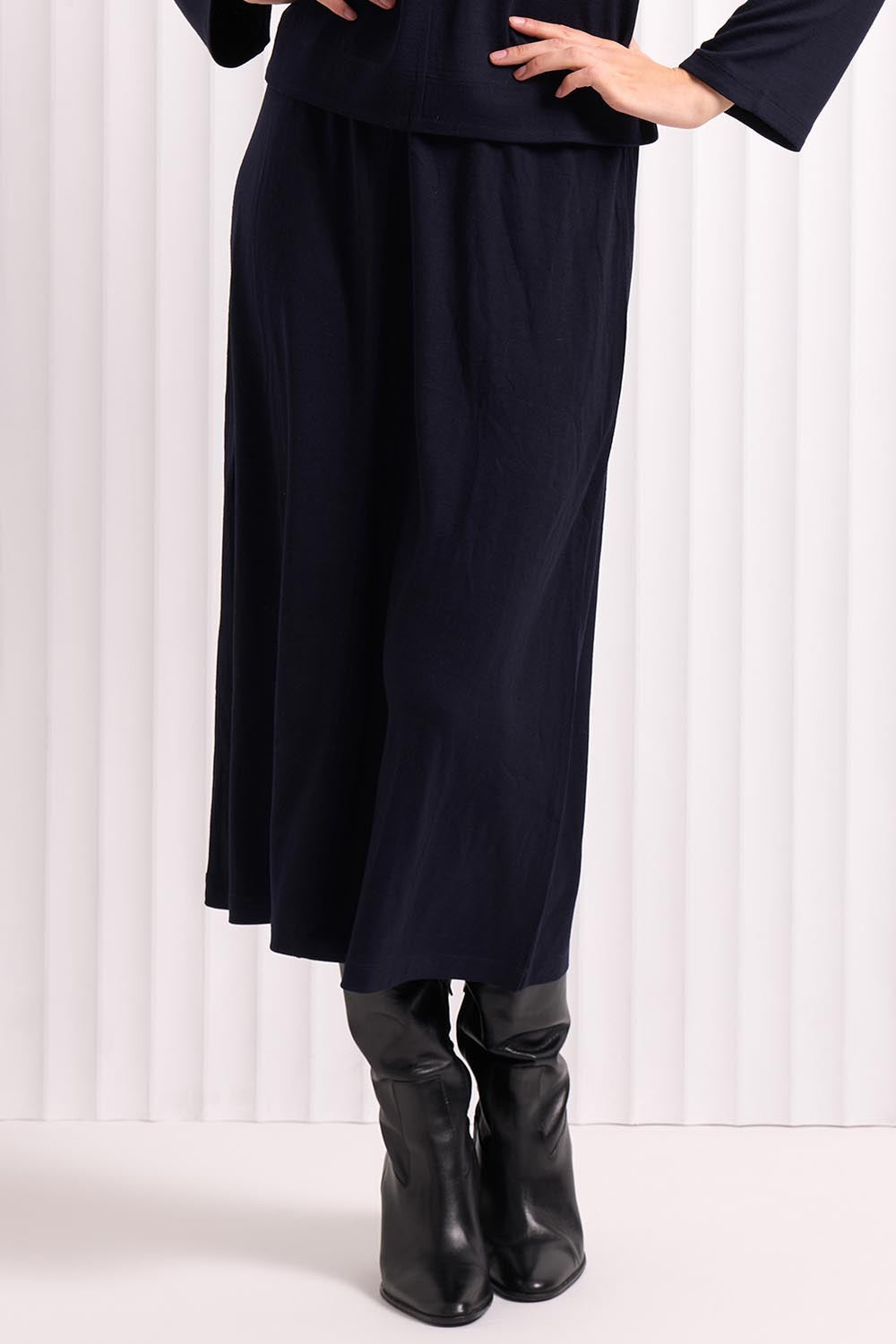 A model wearing the A Game Merino Skirt in colour Futuredusk (Blue), from the front, cropped image