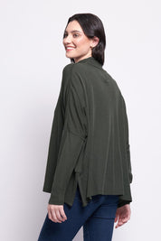 A model wearing the Merino Raisin The Baa Sweater in colour Moss (Green), from the back