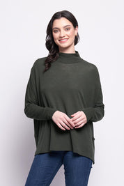 A model wearing the Merino Raisin The Baa Sweater in colour Moss (Green), from the front, cropped image