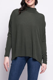 A model wearing the Merino Raisin The Baa Sweater in colour Moss (Green), from the front, cropped image