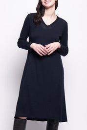 A model wearing the Merino Shear Ecstasy Dress in colour Truenavy (Blue), from the front, cropped image