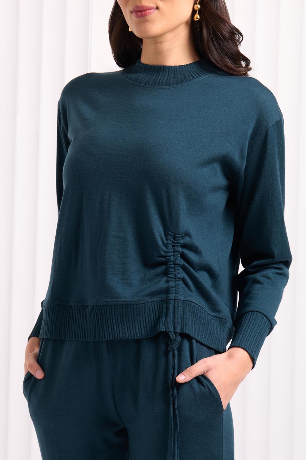A model wearing the Merino Best Side Top in colour Jeep (Green), from the front, cropped image