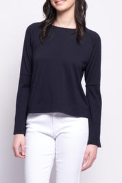 A model wearing the Merino Belong Together Sweater in colour Futuredusk (Blue), from the front, cropped image