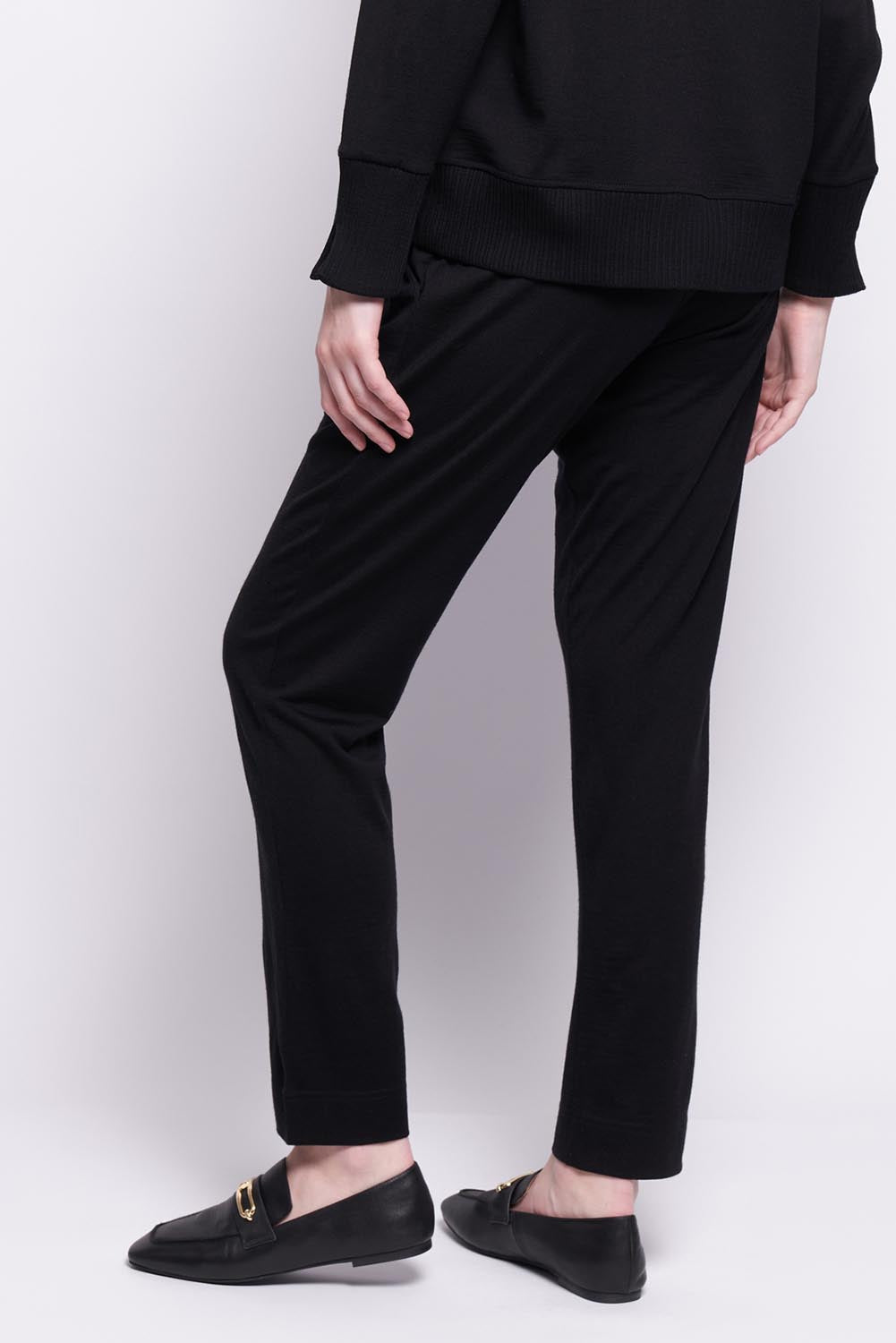 A model wearing the Merino Lazy Sunday Jogger in colour Black (Black), from the front, cropped image