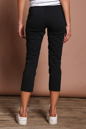 Model Madeline wearing size 10 of the Fuss Free 7/8 Pant in colour Black (Black), from the back