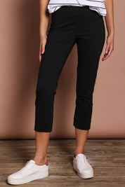 Model Madeline wearing size 10 of the Fuss Free 7/8 Pant in colour Black (Black), from the front, cropped image