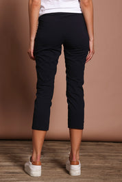Model Madeline wearing size 10 of the Fuss Free 7/8 Pant in colour TrueNavy (Blue), from the back