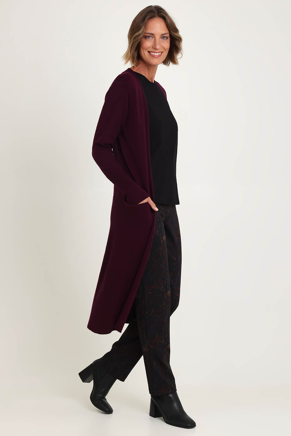 Model Riina wearing size S of the Luxe Line Cardi in colour Cherry (Purple), from the front, showing the whole outfit