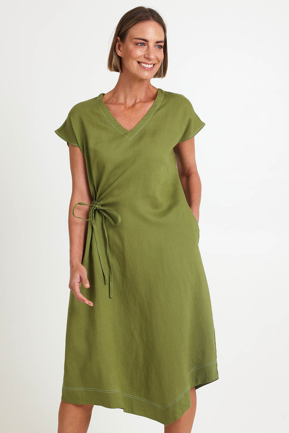 Model Riinar wearing size 10 of the Point Of View Dress – Avocado in colour Avocado, in a cropped view