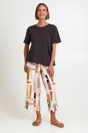 Model Riinar wearing size 10 of the Spliced And Diced Tee – Sable in colour Sable, from the front