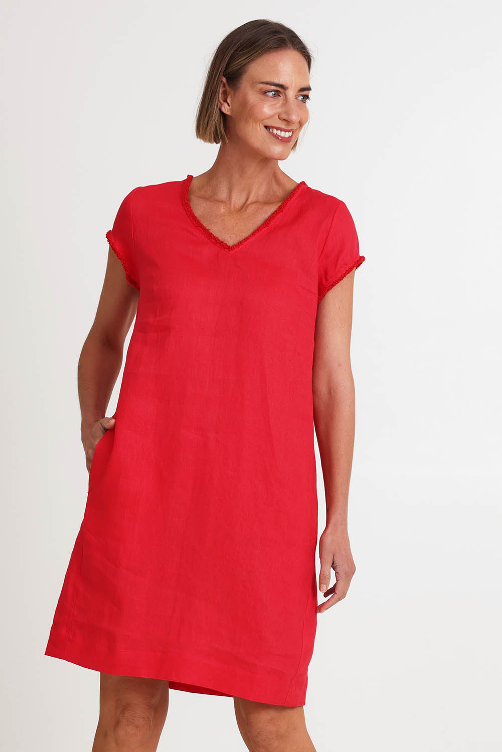 Model Riinar wearing size 10 of the V Festival Dress – Melon in colour Melon, from an angle