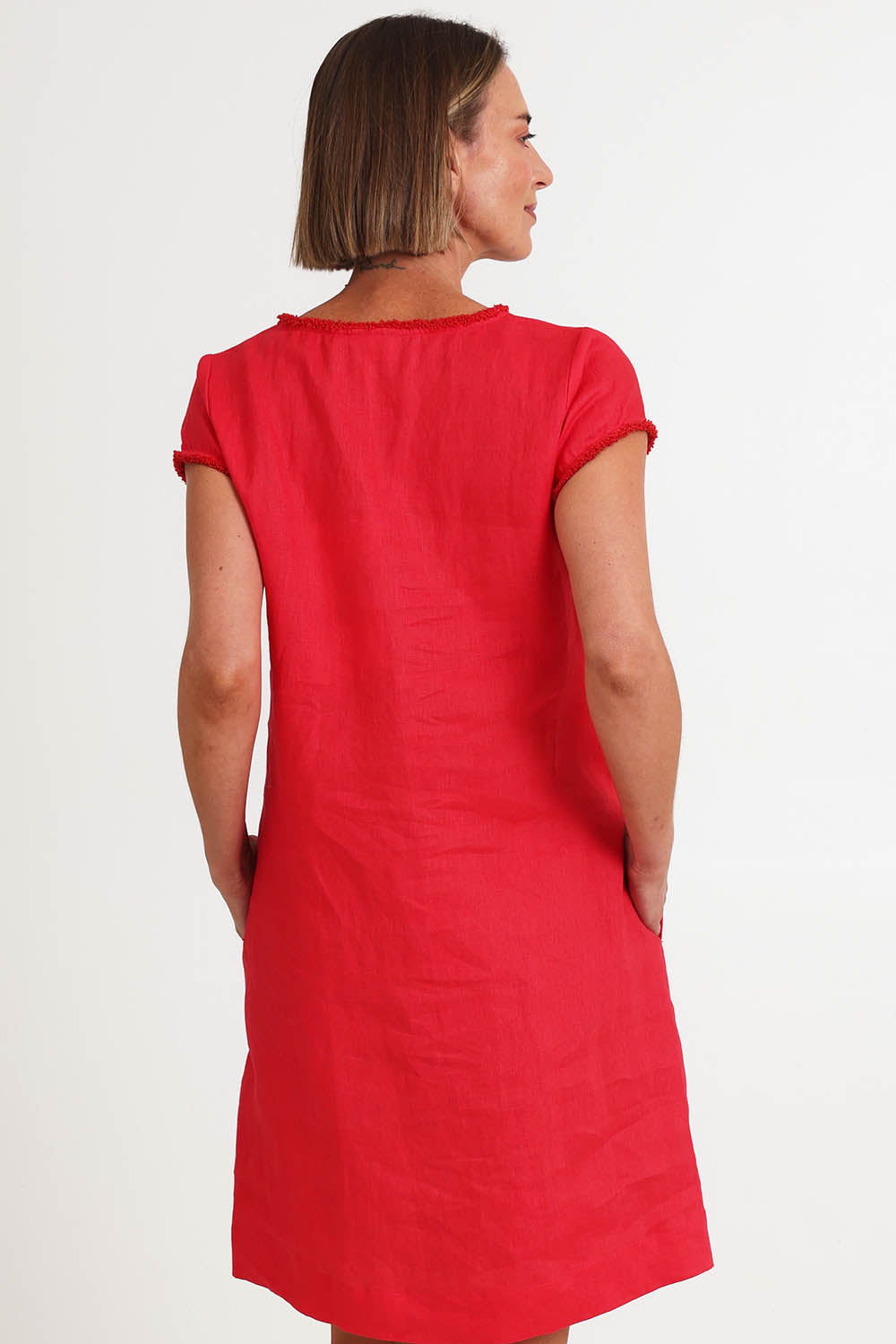 Model Riinar wearing size 10 of the V Festival Dress – Melon in colour Melon, from the back