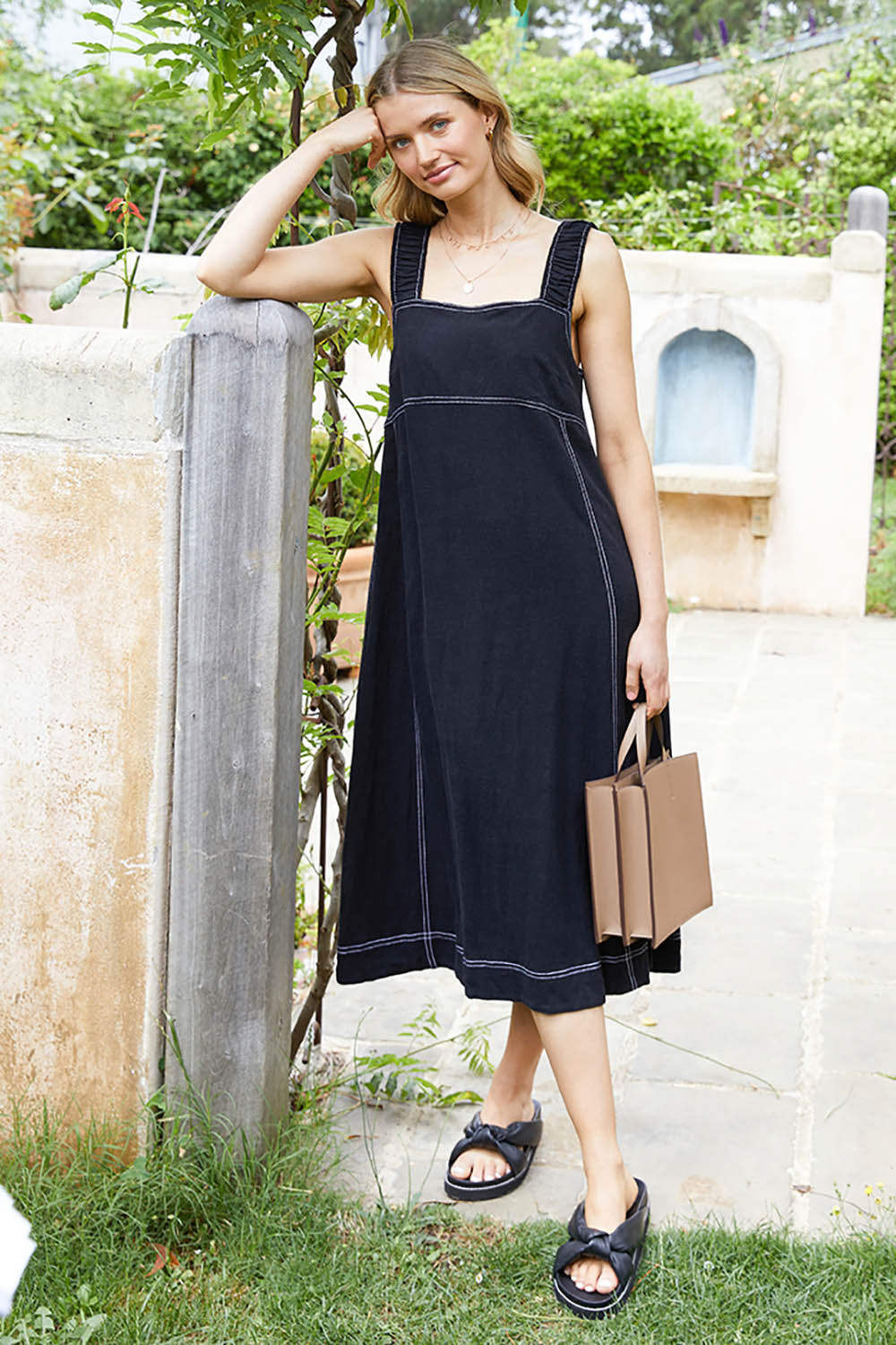 A model wearing the Sage Dress in colour Black (Black), from the front, showing the whole outfit