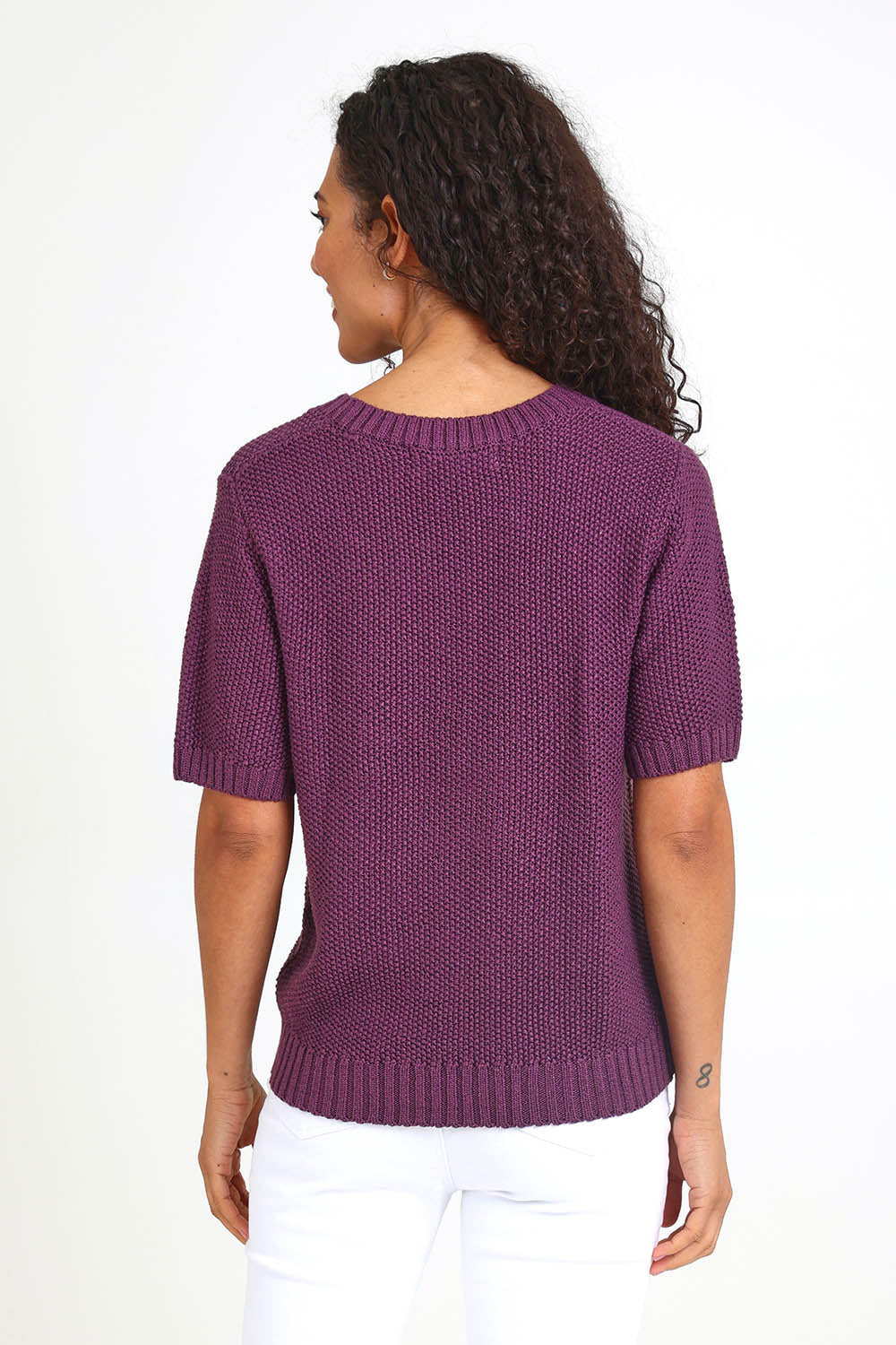 Model Pamelar wearing size 10 of the Blair Short Sleeve Knit – Plum in colour Plum, from the back