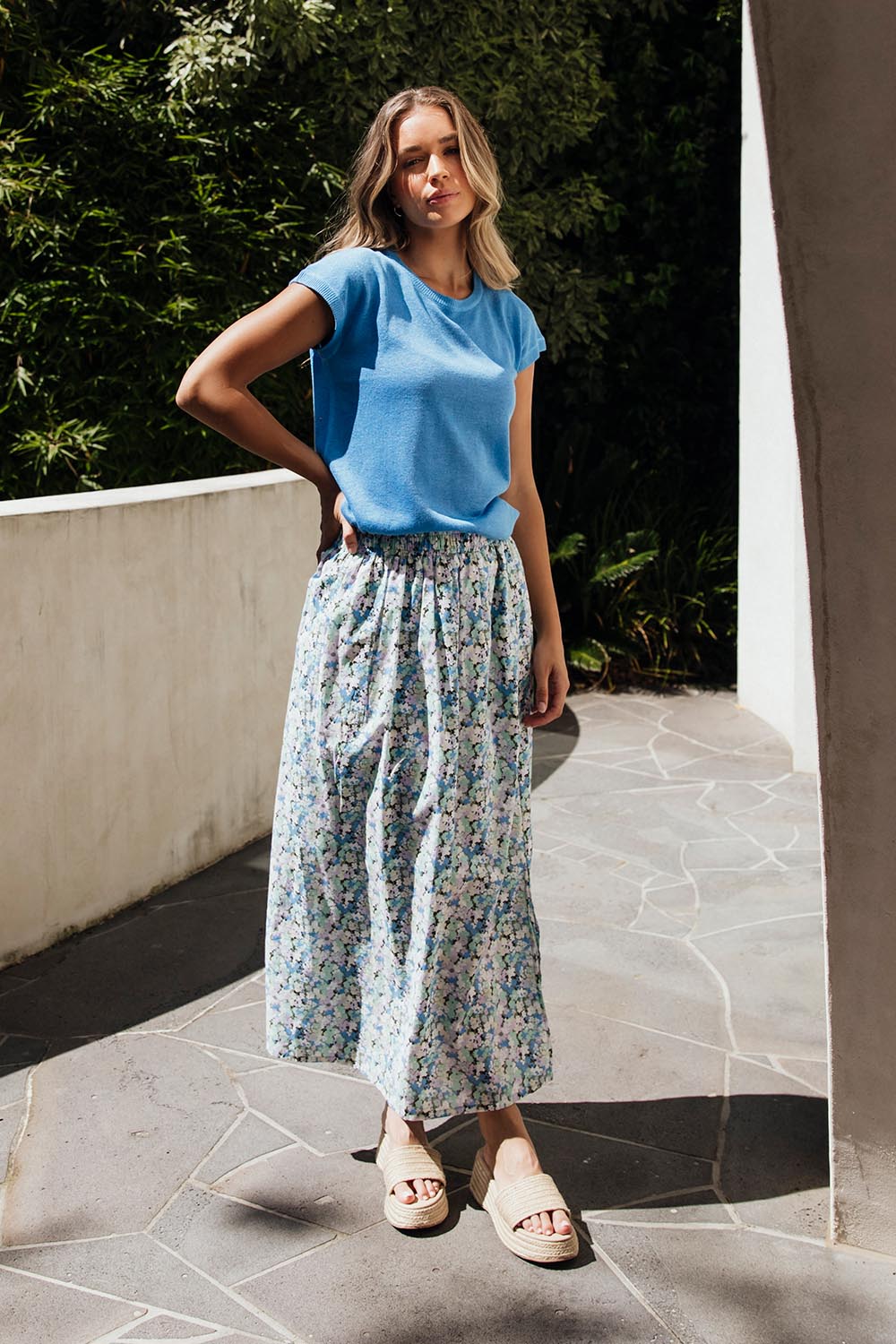 A model wearing the Rosette Floral Skirt in colour Rosette (Blue), from the front, showing the whole outfit