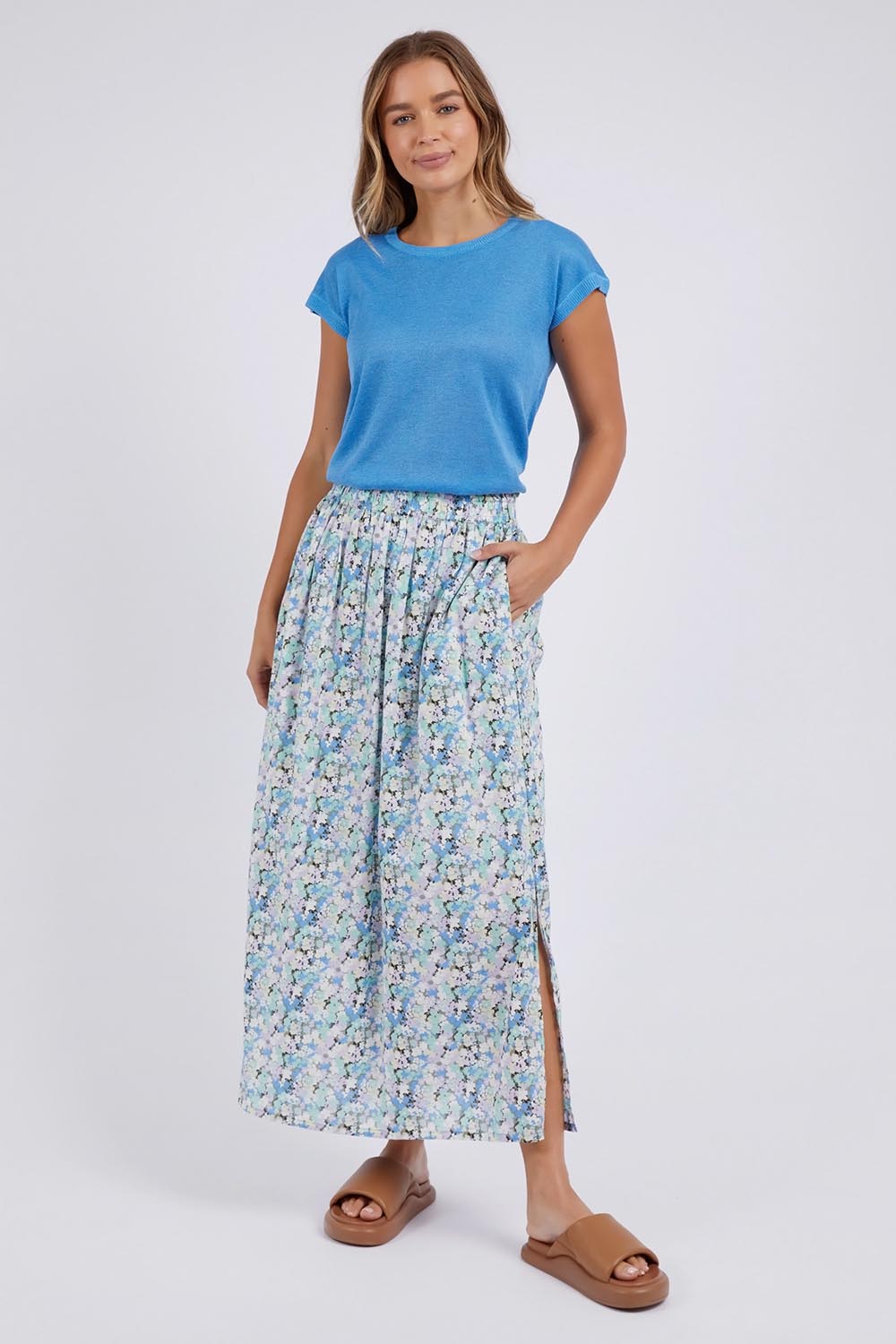 A model wearing the Rosette Floral Skirt in colour Rosette (Blue), from the front, showing the whole outfit
