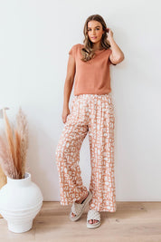 A model wearing the Etched Geo Pant in colour Clay, from the front, showing the whole outfit
