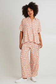 Model Olivia wearing size 10 of the Etched Geo Pant in colour Clay, from the front, showing the whole outfit