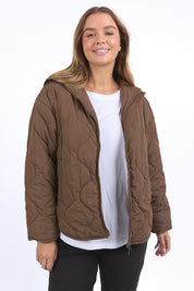 A model wearing the Mellow Quilted Jacket in colour Coffee, from the front, cropped image