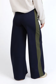 A model wearing the Juno Pant in colour Navygreen (Blue), from the back