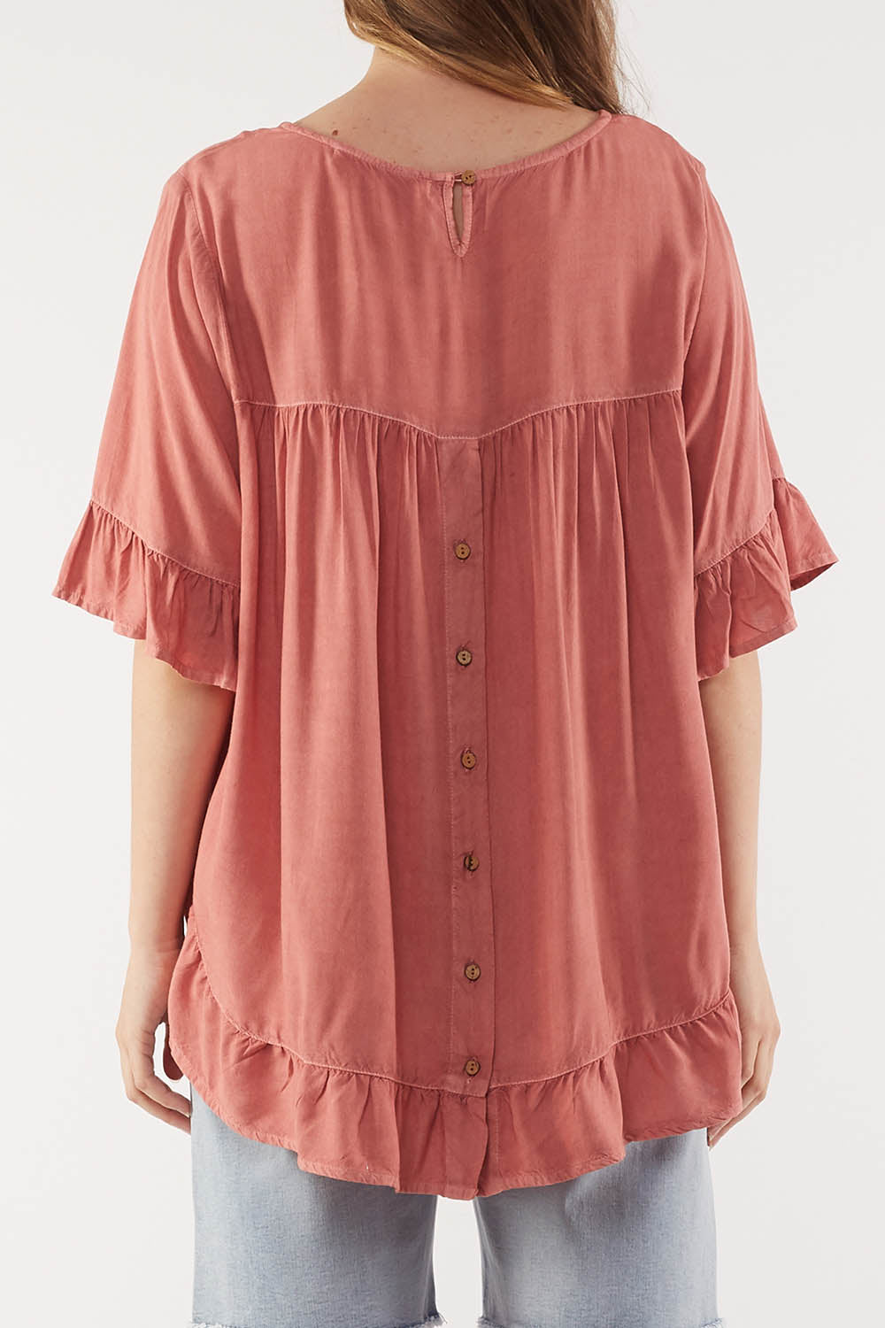 A model wearing the Cassis Top in colour Rose (Pink), from the back