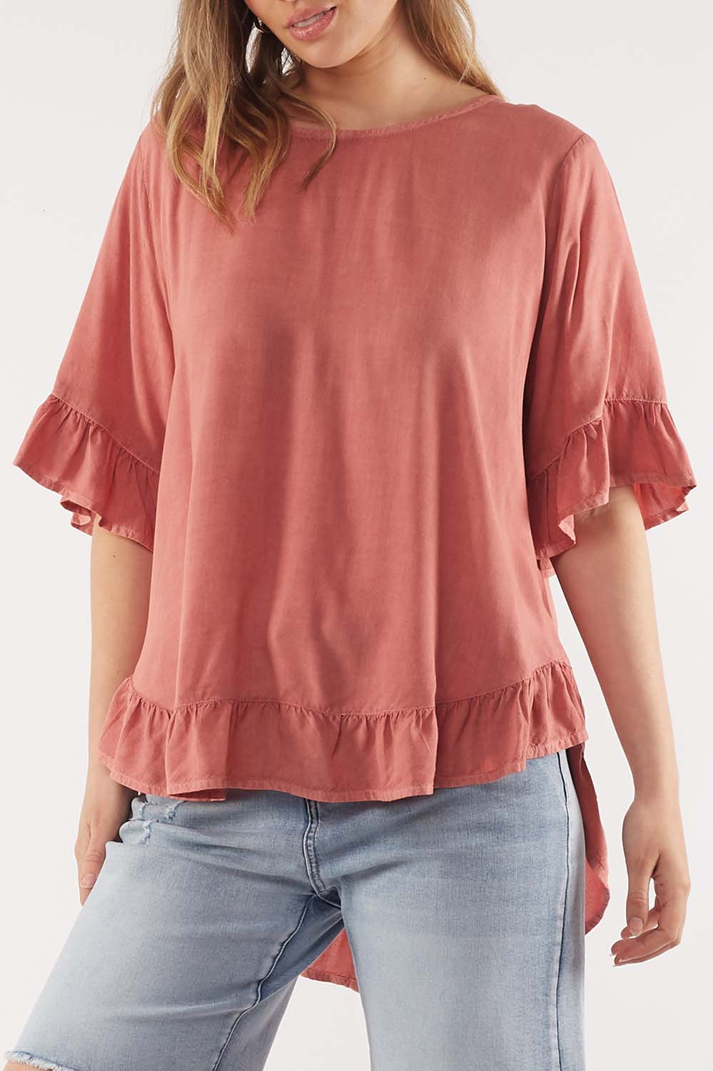 A model wearing the Cassis Top in colour Rose (Pink), from the front, cropped image