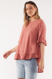 A model wearing the Cassis Top in colour Rose (Pink), from the front, cropped image