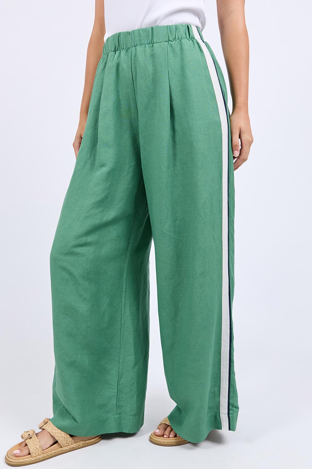 A model wearing the Elemental Linen Blend Pant in colour Deepgrass (Green), from the front, cropped image