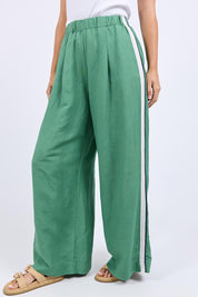 A model wearing the Elemental Linen Blend Pant in colour Deepgrass (Green), from the front, cropped image