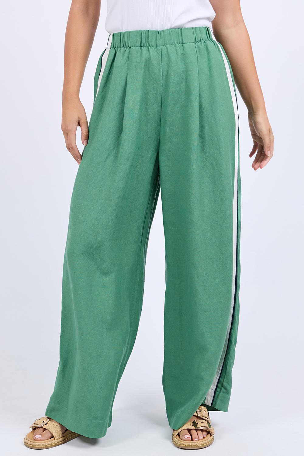 A model wearing the Elemental Linen Blend Pant in colour Deepgrass (Green), from the front, cropped image