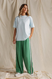 A model wearing the Elemental Linen Blend Pant in colour Deepgrass (Green), from the front, showing the whole outfit