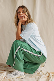 A model wearing the Elemental Linen Blend Pant in colour Deepgrass (Green), from the front, showing the whole outfit