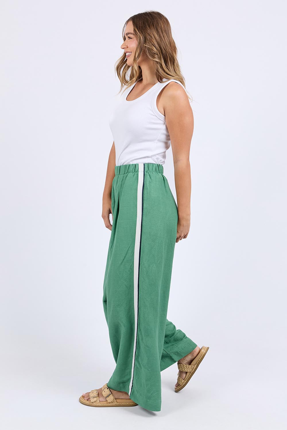 A model wearing the Elemental Linen Blend Pant in colour Deepgrass (Green), from the front, showing the whole outfit