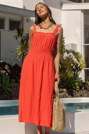 A model wearing the Dandelion Cotton Blend Dress in colour Tangelo, from the front, showing the whole outfit