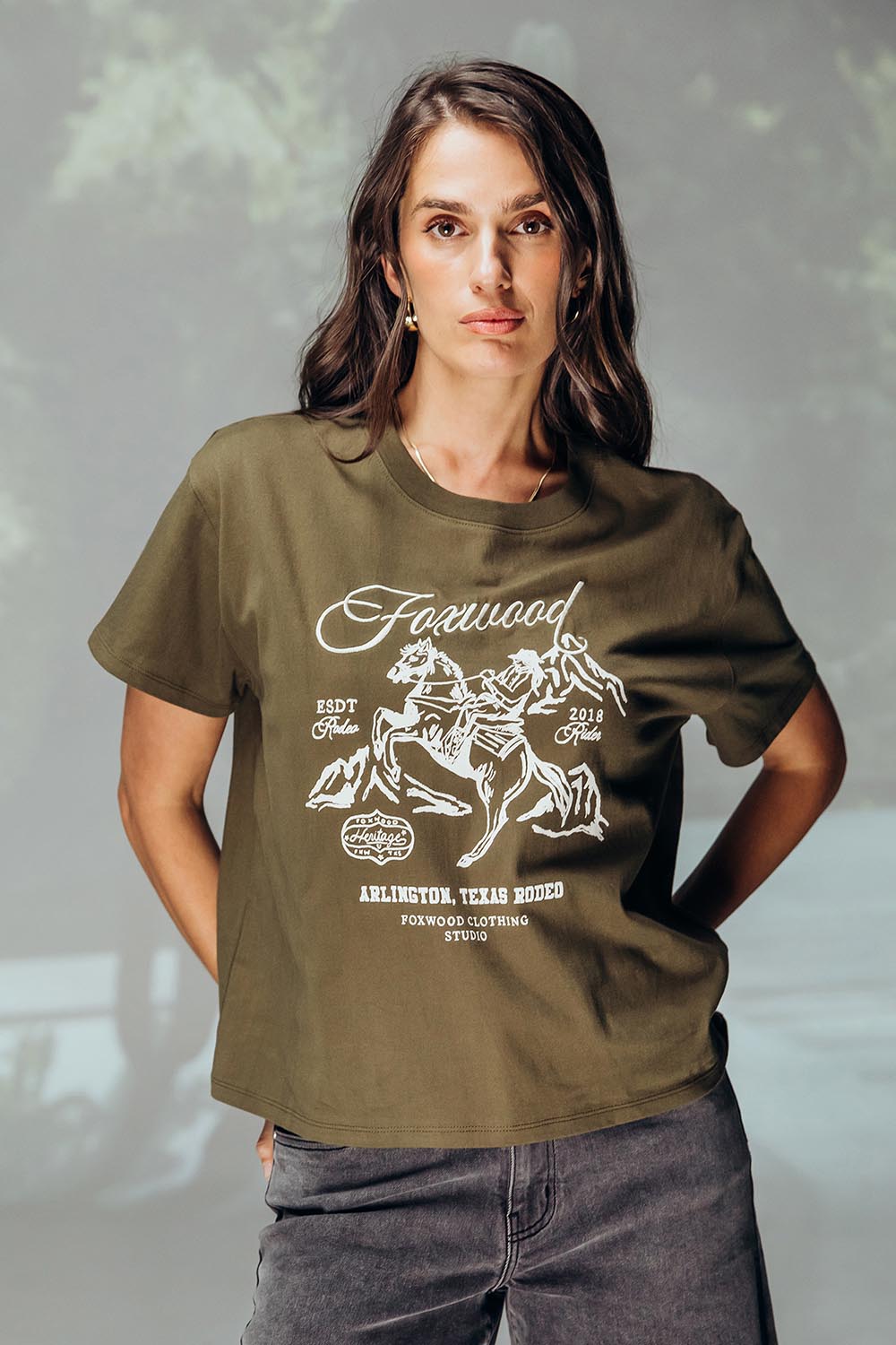 A model wearing the Arlington Cotton Tee in colour Darkolive (Green), from the front, showing the whole outfit