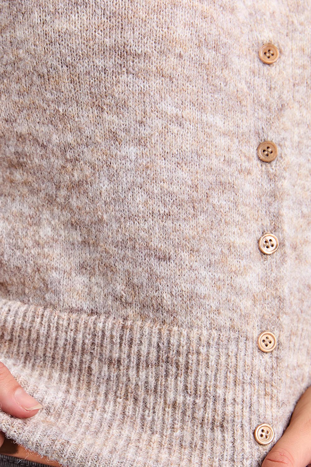 A model wearing the Fernie Button Knit in colour Oatmeal, from the front, cropped image