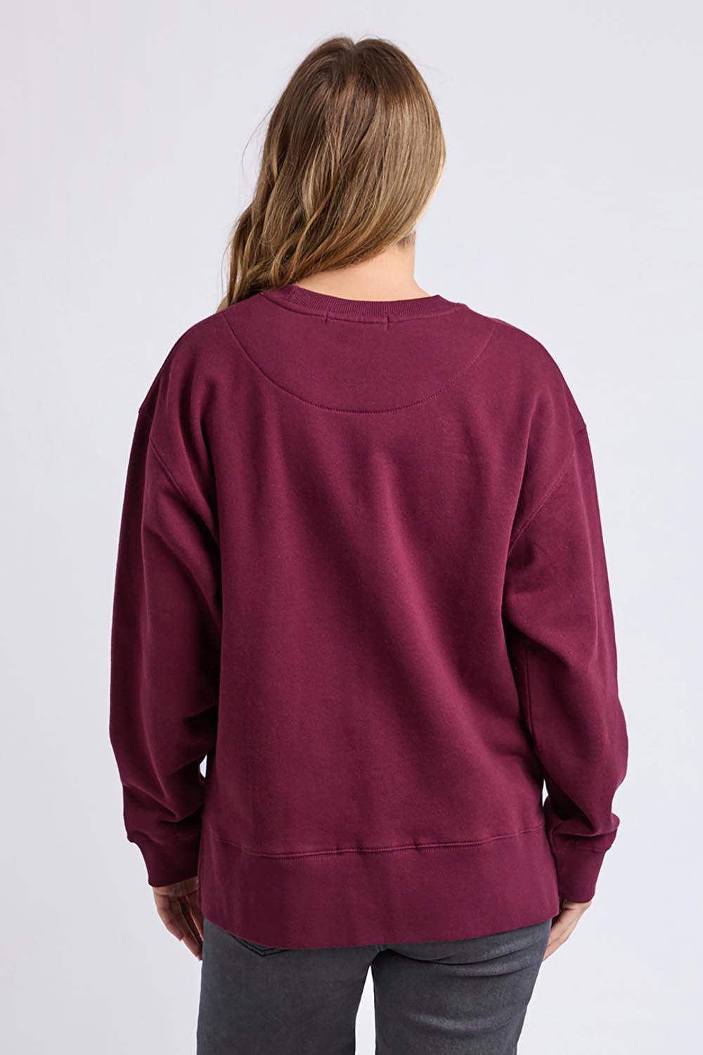 A model wearing the Solace Crew in colour Windwine (Red), from the back