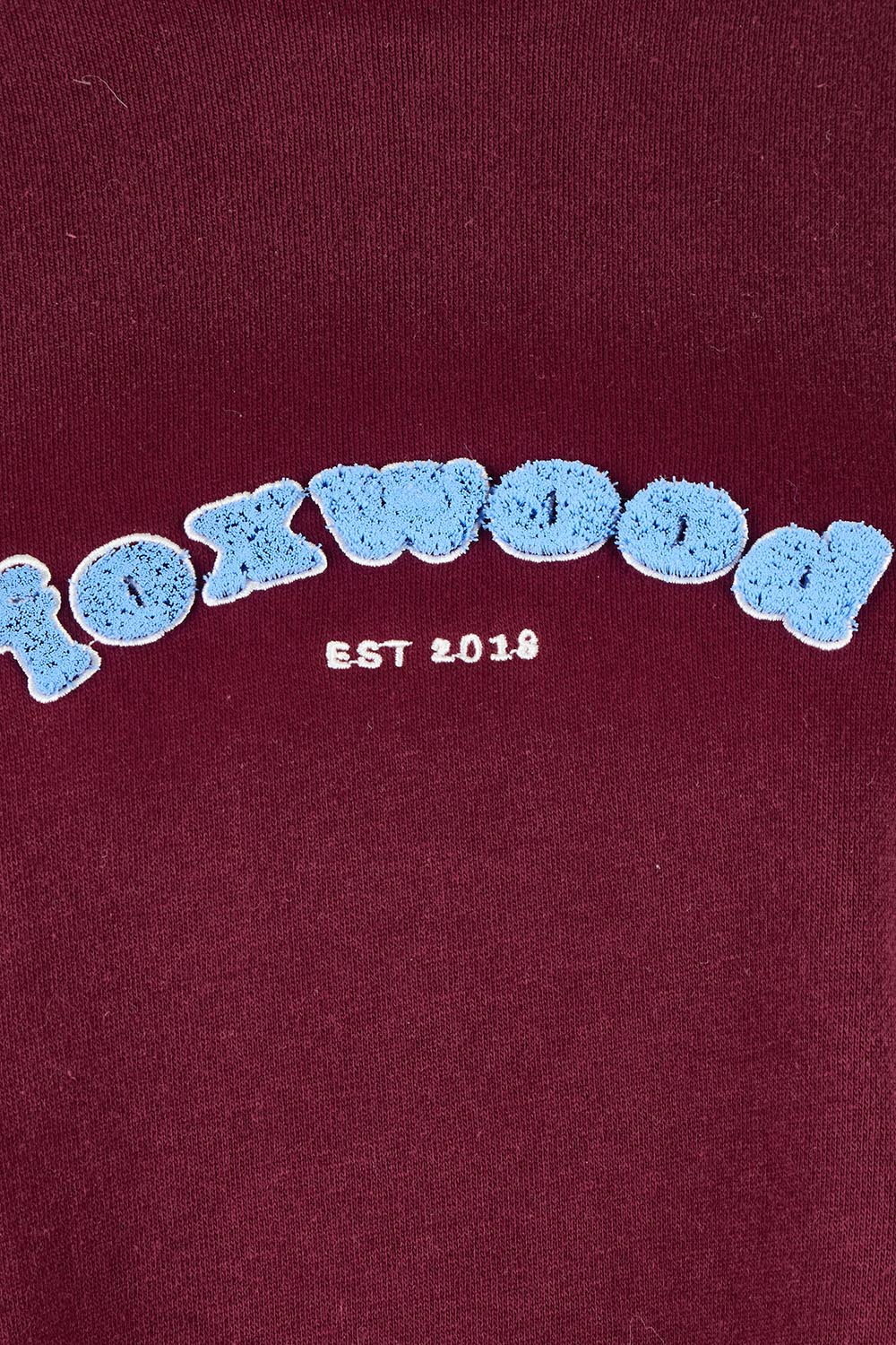 Product shot of the Solace Crew in colour Windwine (Red), detail