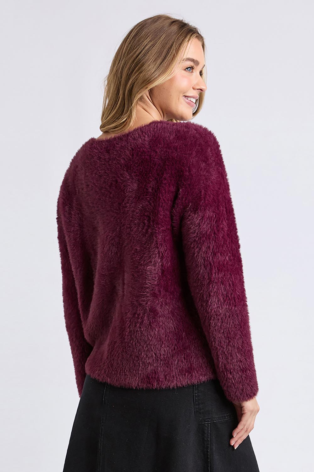 A model wearing the Kenny Button Cardi in colour Windwine (Red), from the back